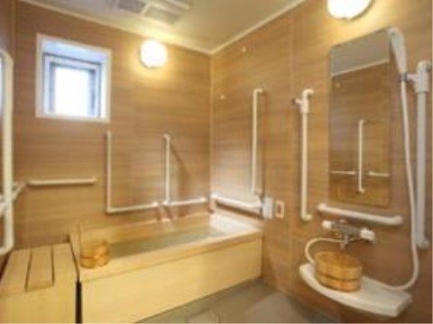 木のぬくもりが温かな浴室には手すりが多数設置されており、立ち上がりの際や浴槽へ入る際に役立っている。