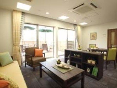 テーブルや棚、ソファが置いてある。グレーの絨毯と大きな窓がある。テラス席もあるので外でお茶を飲むこともでき、開放的な空間である。