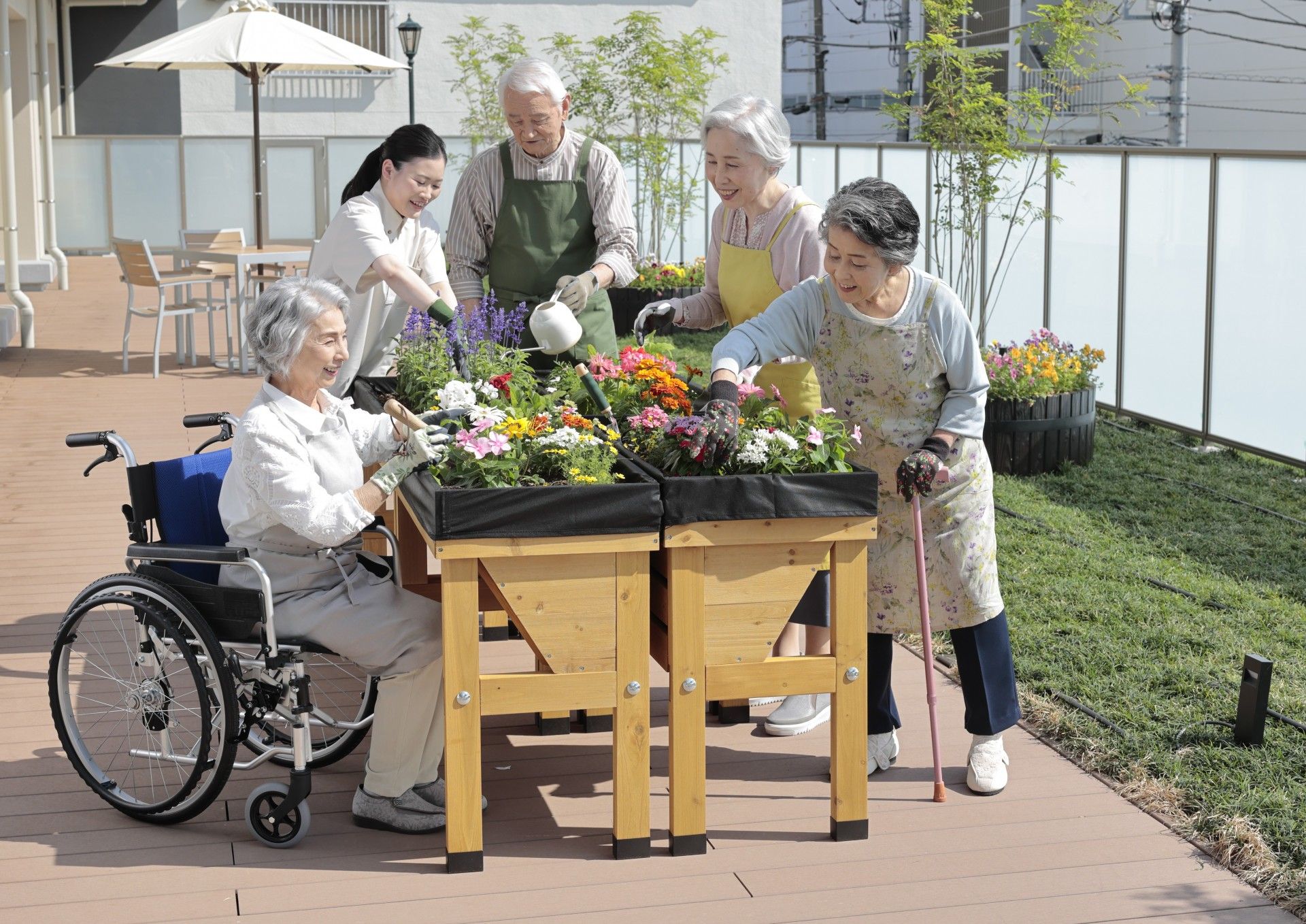 スタッフの指導で、ひも状の布を使い、集団で体操をする入居者様