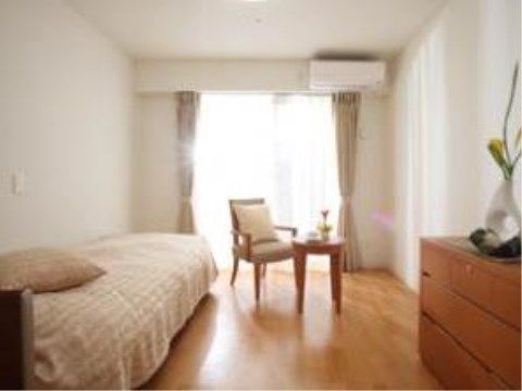 落ち着いた家具が置かれたシンプルな居室である。窓が大きく段差がないため、毎日の生活を快適に過ごすことができる。