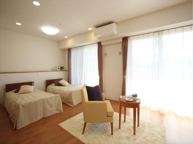 介護用電動ベッドやエアコンが備わったシックで落ち着いた雰囲気の居室