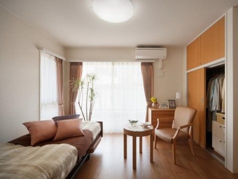 壁際にはベッドがあり、ベッドの上にはクッションが置かれている。クローゼットはスライド式のドアで、洋服などをかけて収納できる。