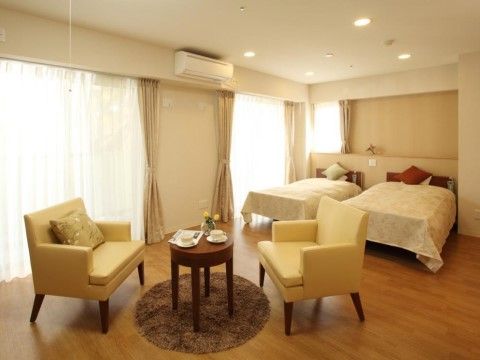 広々とした２人部屋。ベッドが２台並んでいる。テーブルを挟んで向かい合わせに椅子が２脚置かれている。家具を置いてもスペースに十分余裕がある。