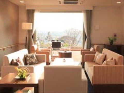 正面に窓がある明るい部屋に、ソファセットが並んでいる。窓からはウッドデッキ越しに外の景色を楽しめる。