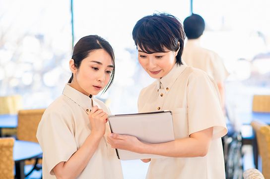 ティータイムを楽しまれているご利用者様へお話をする職員