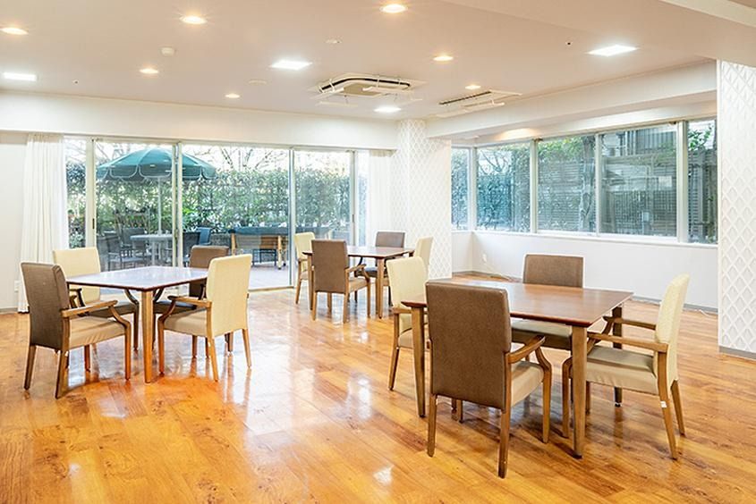 複数のテーブルにカラフルな椅子やソファが置かれている。陽の光により明るく落ち着いた室内になっている。