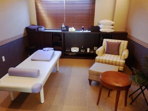 白と薄紫のマッサージ台と一人用のソファ、オットマンが置かれたリラクゼーション用の部屋で、疲れを取ることができる。