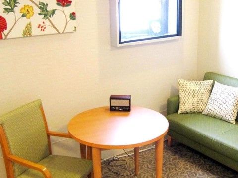 窓があり明るい室内には、ソファと一人掛けの椅子、丸いテーブルがある。落ち着いた家庭的な雰囲気である。