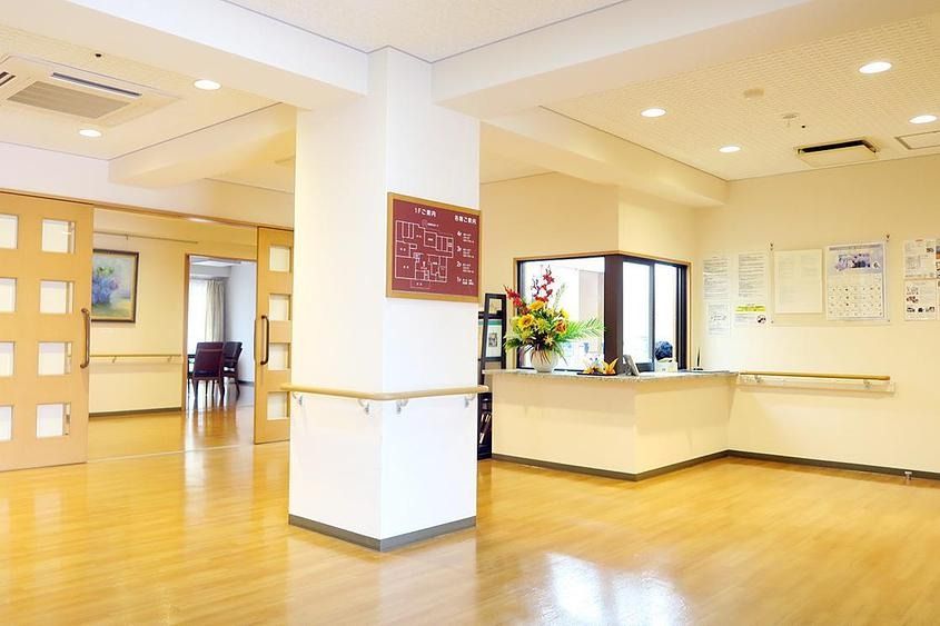 白い壁とウッド調のフロアが清潔感のあるエントランスフロア