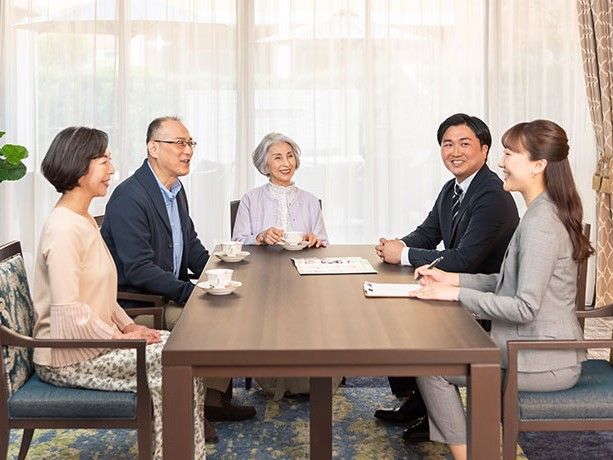 多くの植栽のある庭園を車いすで散策している男性入居者様