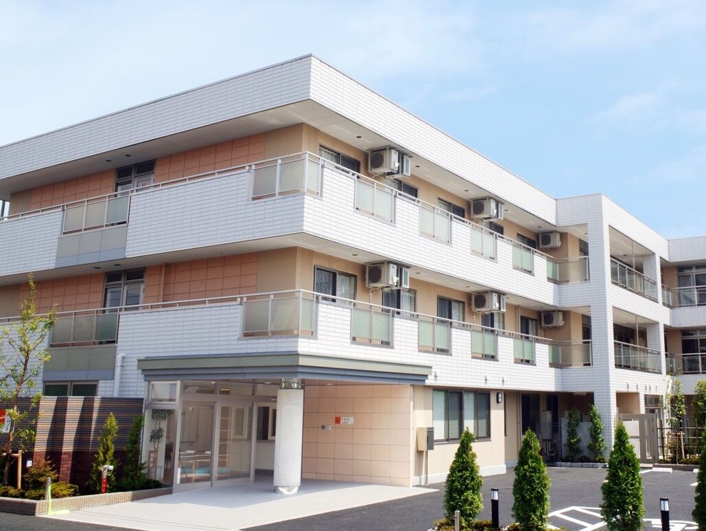 白色と淡いベージュ色の外壁で明るい雰囲気の施設になっている。出入口は道路から直近にあり速やかに入室することができる。