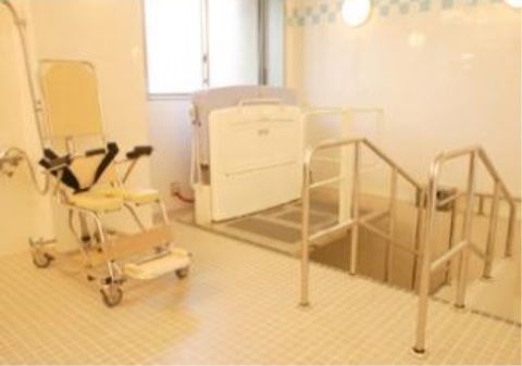 浴槽の左側には車輪が付いた移動可能な介助用の椅子があり、入居者様は腰を掛けた状態で楽に入浴することができる。