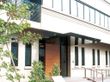 モダンな雰囲気の外壁と数本の木々がある施設の建物外観