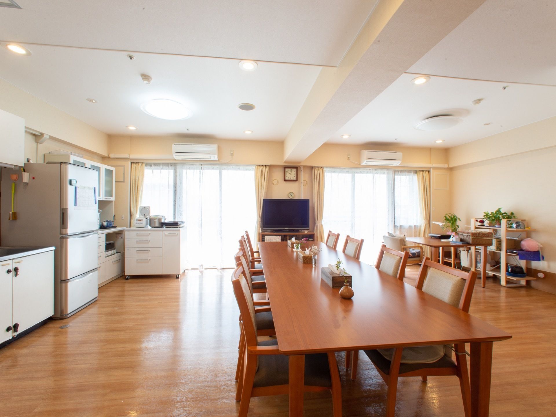 調理器具が揃ったキッチンと長いテーブルがある交流室