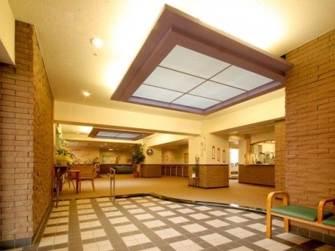 あたたかい雰囲気のあるエントランスである。手すり付きのスロープが設置されており、ホールには受付カウンターが設けられている。