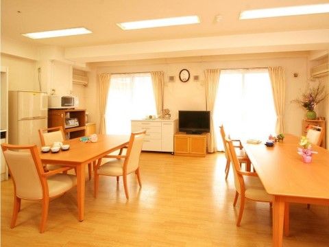 大きな窓が設置されたリビングでは、明るい木製で温かみのあるダイニングテーブルと椅子が配備されている。