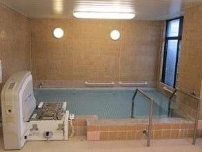 機械浴のための装置が据えられた、広々とした浴槽がある浴室