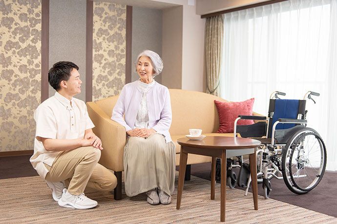 ごはん茶碗を片手に持って、男性スタッフと談笑している男性入居者様