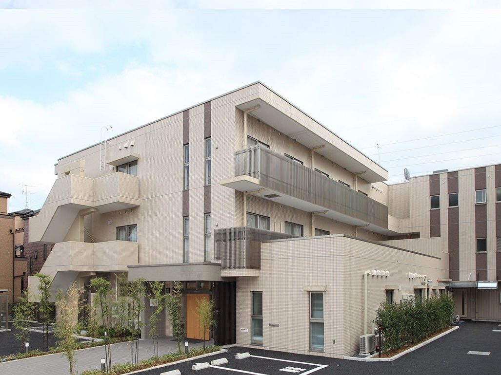 施設は、白を基調としたシンプルな外観となっている。敷地内には、広々とした駐車スペースが設けられている。