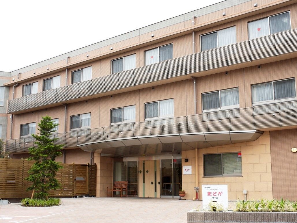 ベージュ色の３階建てで、敷地入口から玄関までは舗装されている。敷地両側には低い花壇がある。玄関前には３階まで届きそうな大きな木がある。