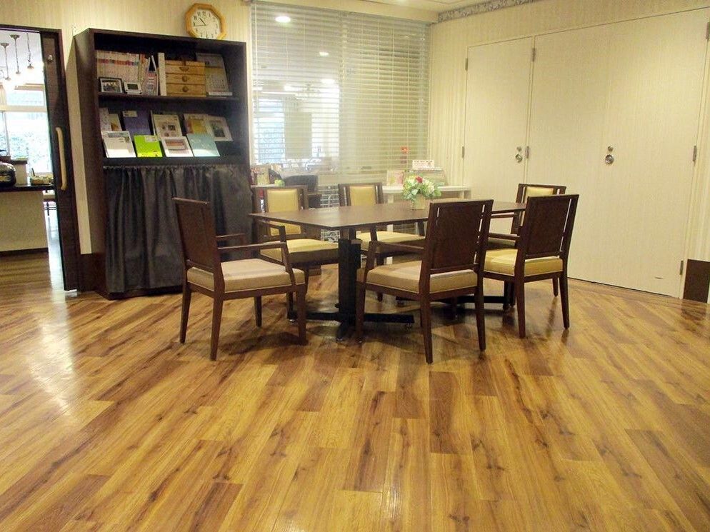 6人掛けのテーブルと本棚が置かれたダイニング横の談話室