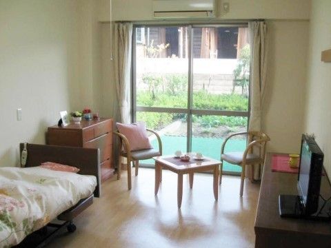 個室内は白い壁で、床は木のぬくもりを感じられるフローリングである。窓から緑のある庭を見ることができる。