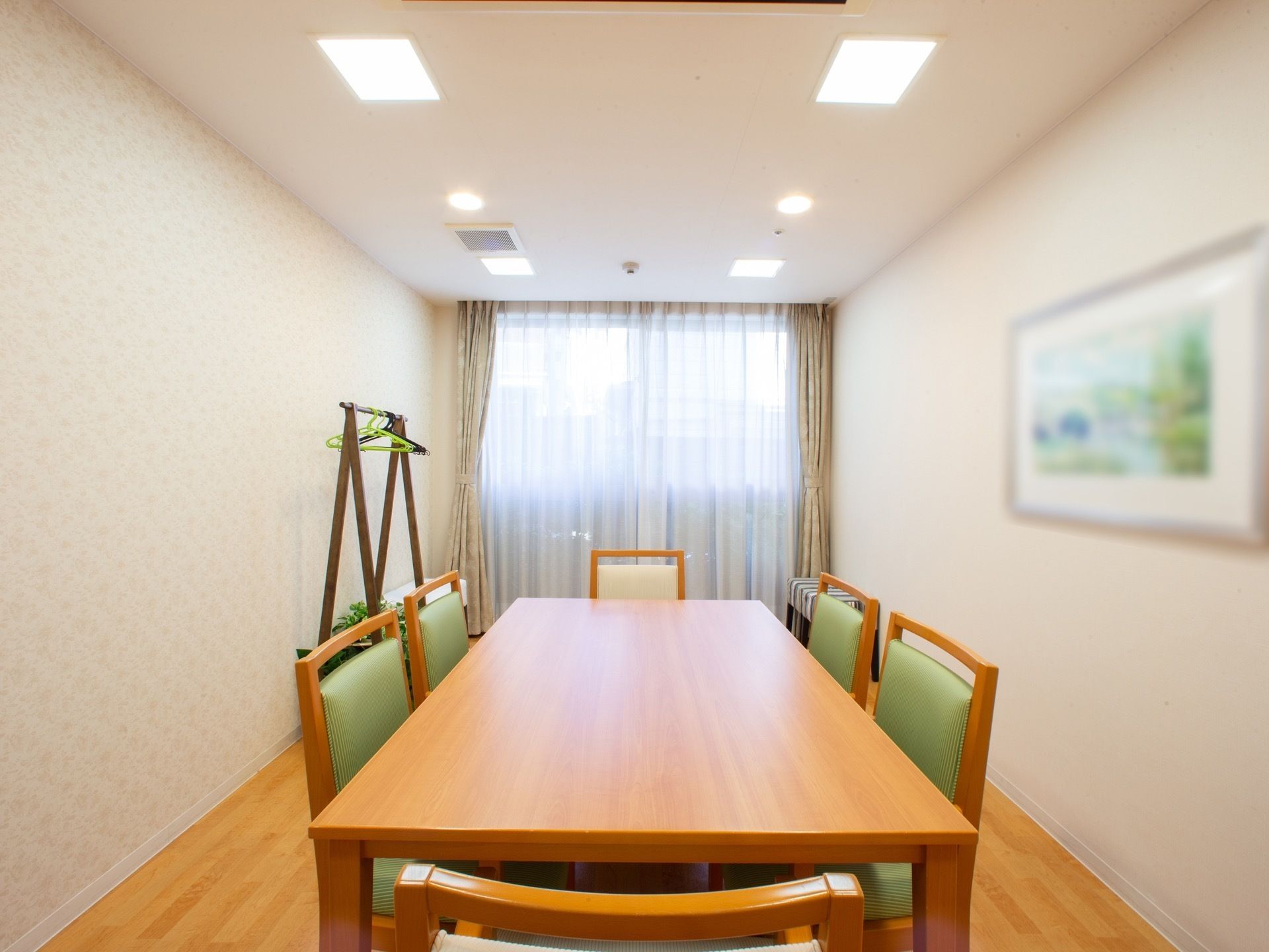 部屋の中央に6人掛けのダイニングテーブルが設置されている談話室