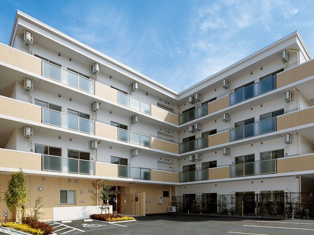 ４階建ての白い建物で、１階部分のみベージュに外壁が塗られている。玄関横には車椅子専用車両の駐車スペースがある。