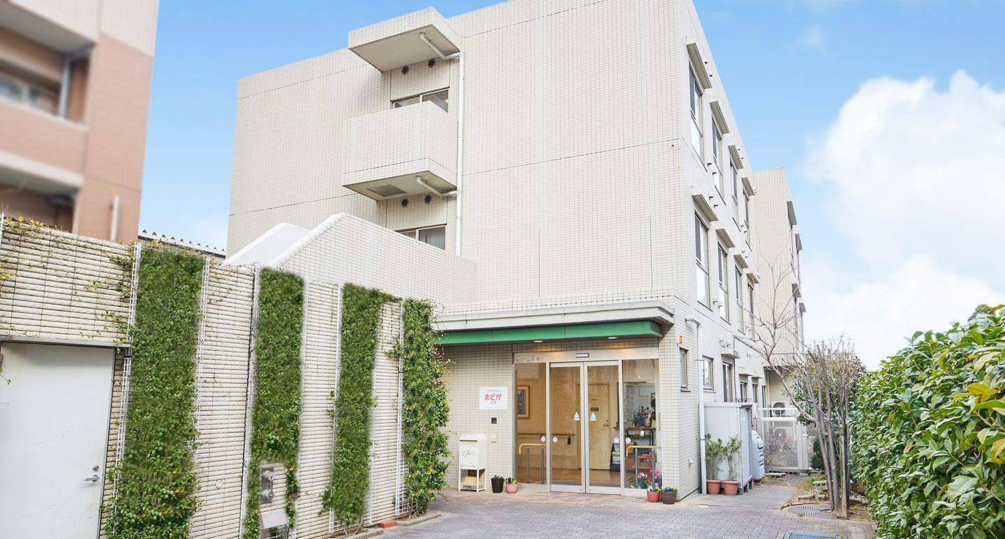 真っ白な３階建ての建物である。玄関は自動扉で、入り口前は屋根があり、扉の横に施設名の看板が取り付けられている。