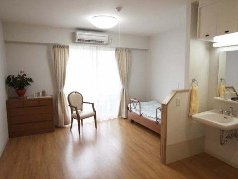 壁は白色で、床は茶色のフローリングを使用しており、ナチュラルな雰囲気である。十分な広さのある居室で、車椅子をご利用の方も楽に移動できる。