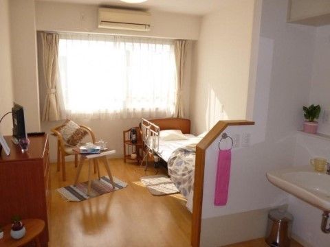 居室にはベッド、コーヒーテーブル、椅子、チェスト、飾り台が置かれ、エアコン完備の部屋である。入口近くには洗面台も設置されている。