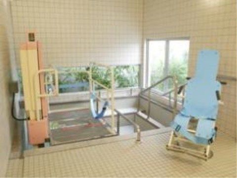 浴室は広くてタイル張りになっており、２方向に窓があって明るい。介護入浴機器が設置されており、浴槽には手すりがついている。