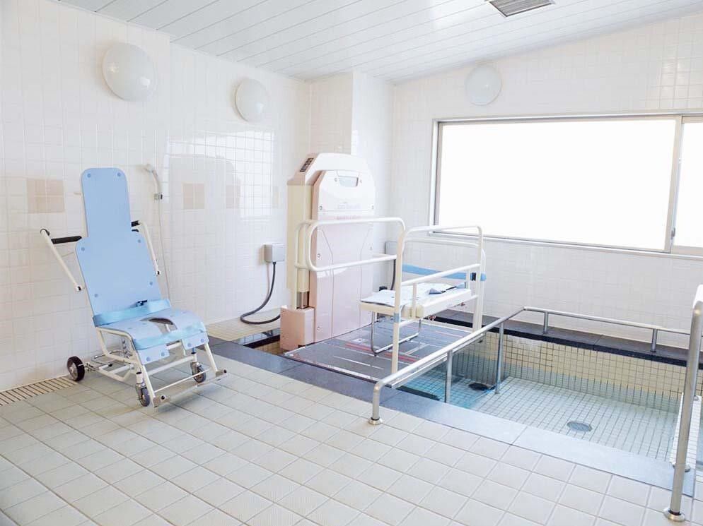 窓がある明るい浴室内には、背もたれが高い車椅子に座ったまま入れる電動リフト付き浴槽がある。通常入浴もできる。