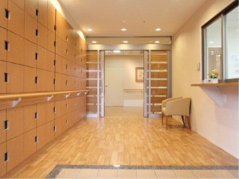 エントランスの床はフローリングになっており、靴箱が設置されている。手すりが設置されているので安全である。