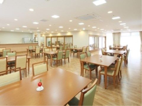 広々としたスペースの床はフローリングで、テーブルや椅子が置かれている。高い天井にはエアコン、照明設備が整っている。
