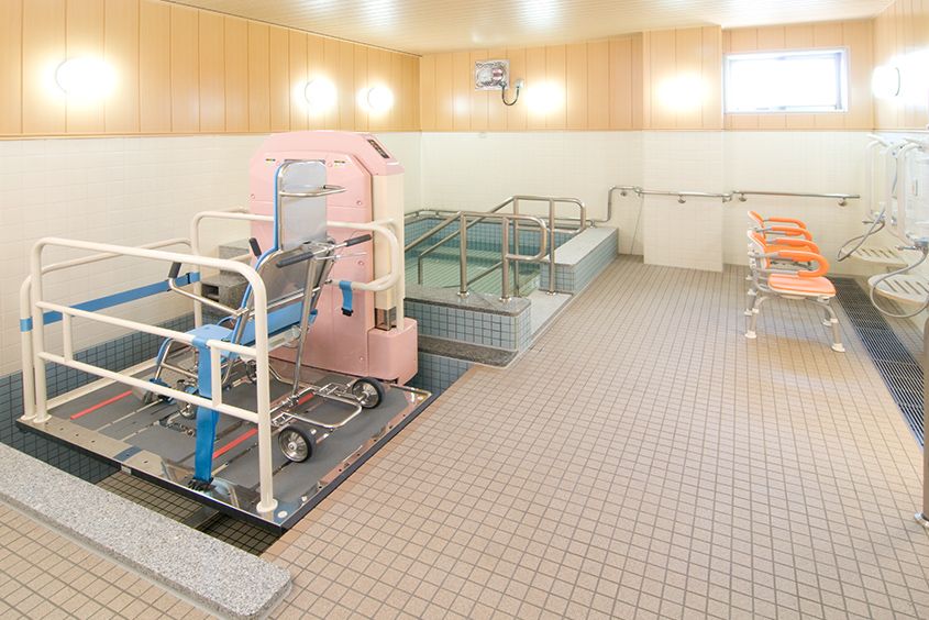 広い浴室で浴槽と機械浴槽が併設されている。洗い場は２か所設置されており、その前にはシャワーチェアが用意されている。