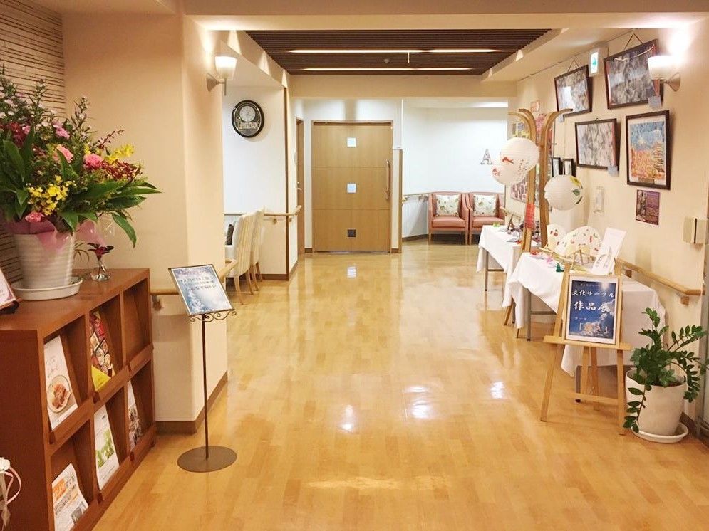 花瓶が飾られた棚やソファ、入居者の作品が置かれたエントランス