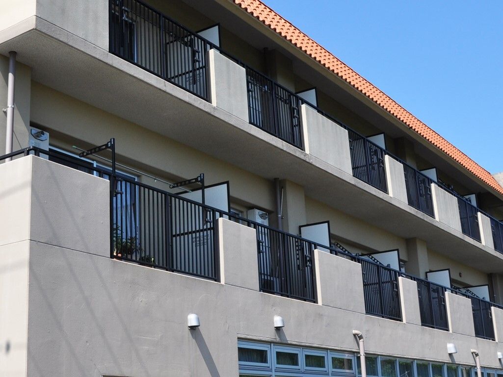 オレンジの瓦屋根、白色で塗られた3階建ての建物