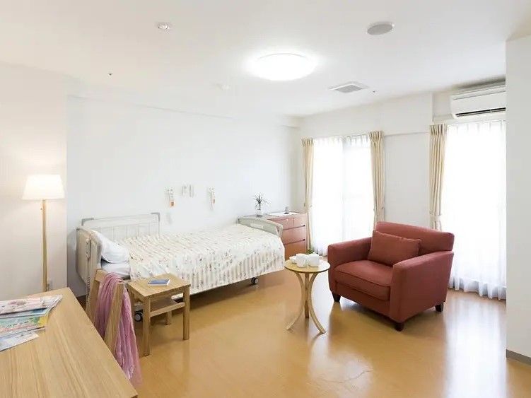 スリッパをしまう収納棚があり、その上には花や雑貨が置かれている。壁にはたくさんの郵便受けが取り付けられている。