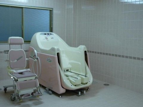 介助入浴機器が設置されたタイル張りの浴室