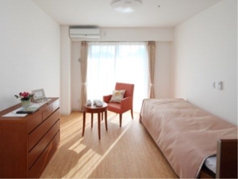 フローリングの床の部屋にベッド、丸テーブル、椅子、調度品などが置かれている。エアコンが完備され、年間を通して快適に過ごすことができる。
