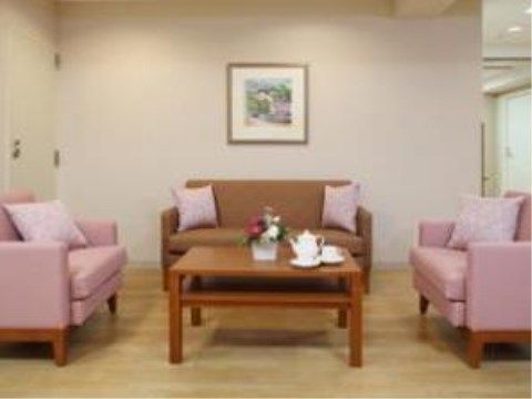 中央に四角のテーブルが置かれている部屋。その左右にはピンクのソファ、奥には茶色のソファが置かれている。