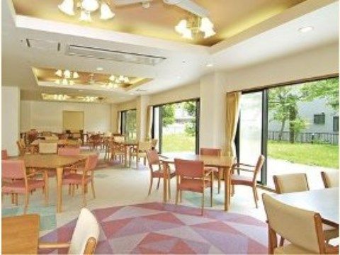 ダイニングの床はタイルカーペット敷きで、その手前側は薄紫色で模様が形成されておりデザイン性のあるものになっている。