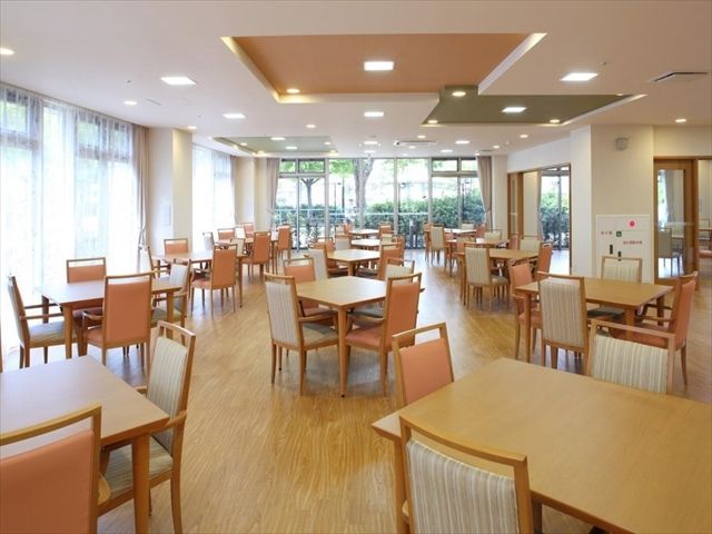 広々として明るい、多数の椅子とテーブルの置かれた食堂