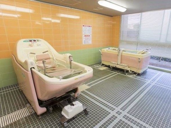 種類の違う2つの介護浴槽がある、タイル張りの広い浴室