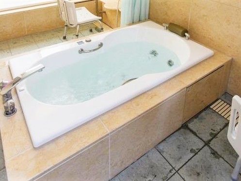 2脚のシャワーチェア、1つの浴槽がある広いおしゃれなお風呂