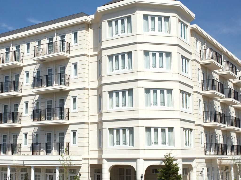 施設は白色のおしゃれな５階建ての建物である。２階より上階には日当たりの良いベランダがある。窓の多い明るい構造である。