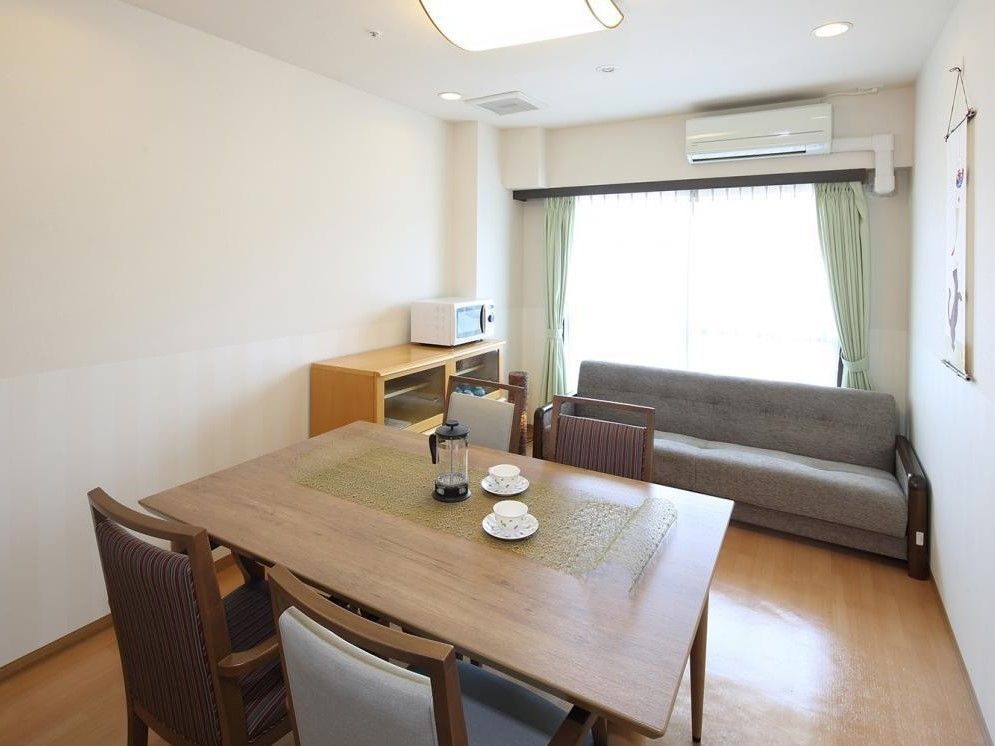 3人掛けのソファと4人用のダイニングテーブルがある部屋