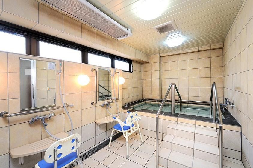 四角形や六角形のダイニングテーブルがたくさん並べられた、フローリング張りの広間