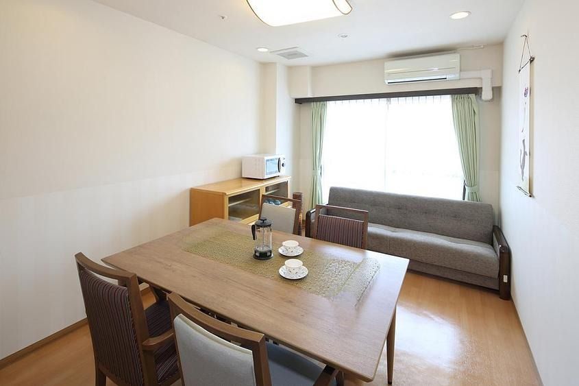 手すりが取り付けられた木製の浴槽が設置された個浴用浴室